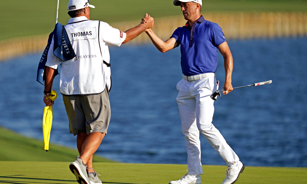 Justin Thomas shaking hands with his caddie.