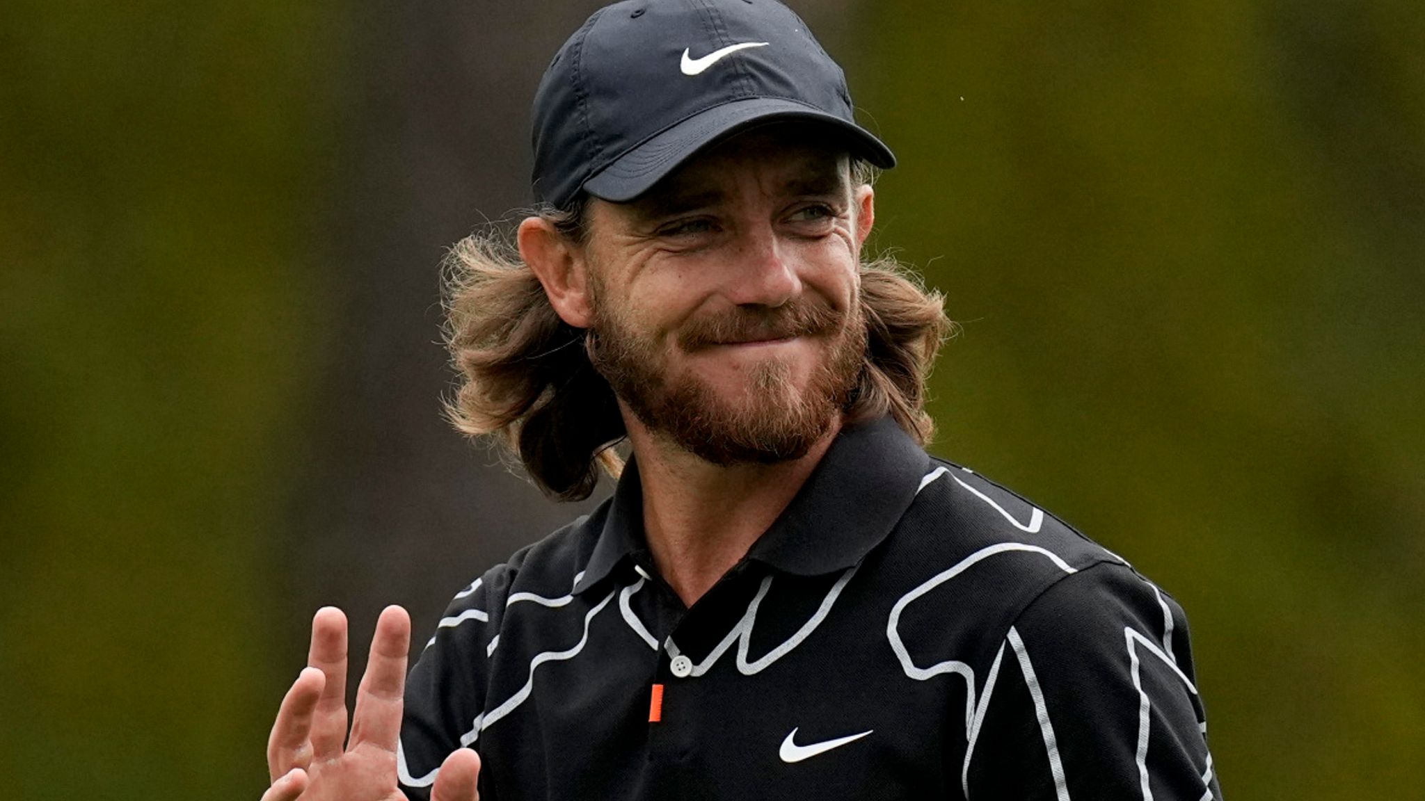 Tommy Fleetwood waving to the crowd after sinking a putt at the 2021 Masters.